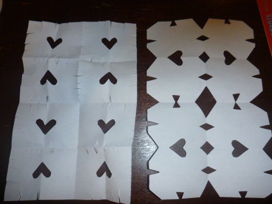 T's snowflake on the left, mine on the right. He wanted to cut fringe after folding his paper, and I helped him add the heart.