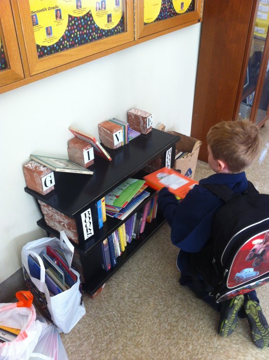 T placing his donations on the shelves for his school's used book drive. This was held as part of the activities for Read Across America 2013.