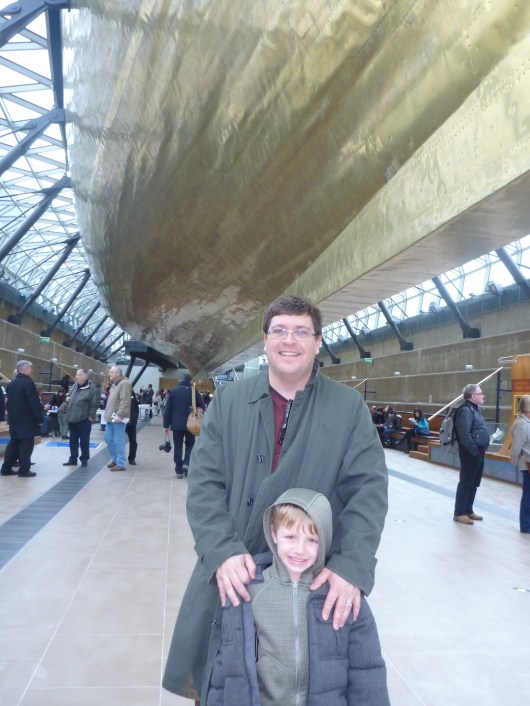 C and T under the hull of Cutty Sark, showcasing the original wood and copper construction of the ship.