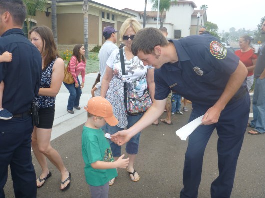 T gets stuck with stickers by a firefighter during the La Mesa Firefighters Local 4759 pancake breakfast last Sunday.