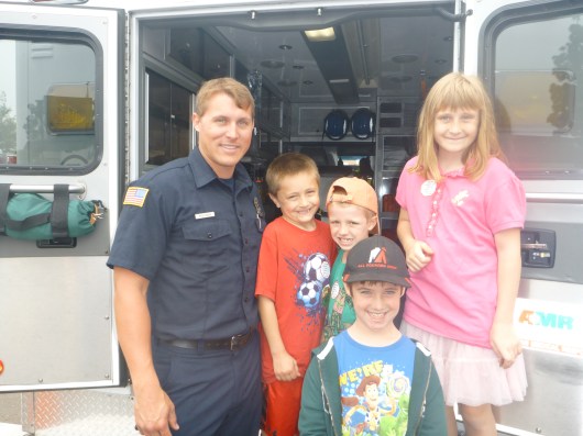 The kids pose with a paramedic who had his truck open and on display during the pancake breakfast at La Mesa Fire Station 11 last Sunday.
