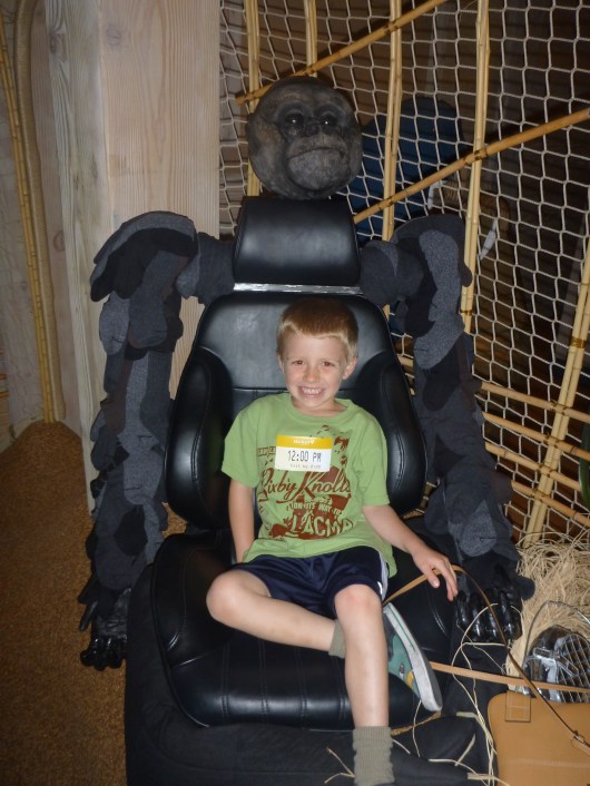 T sits on the gorilla's "lap" (an old car seat) at Noah's Ark.