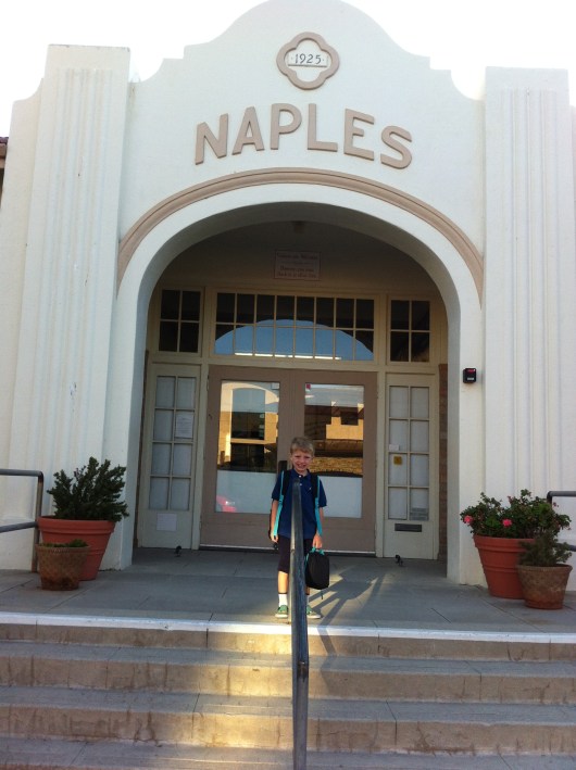 T on the front steps of his new school.