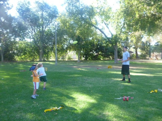 Coach Chris warming up two kids at once at the first flag football practice of the season!