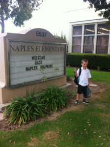 Traditional first day of school photo in front of school sign (combo face).